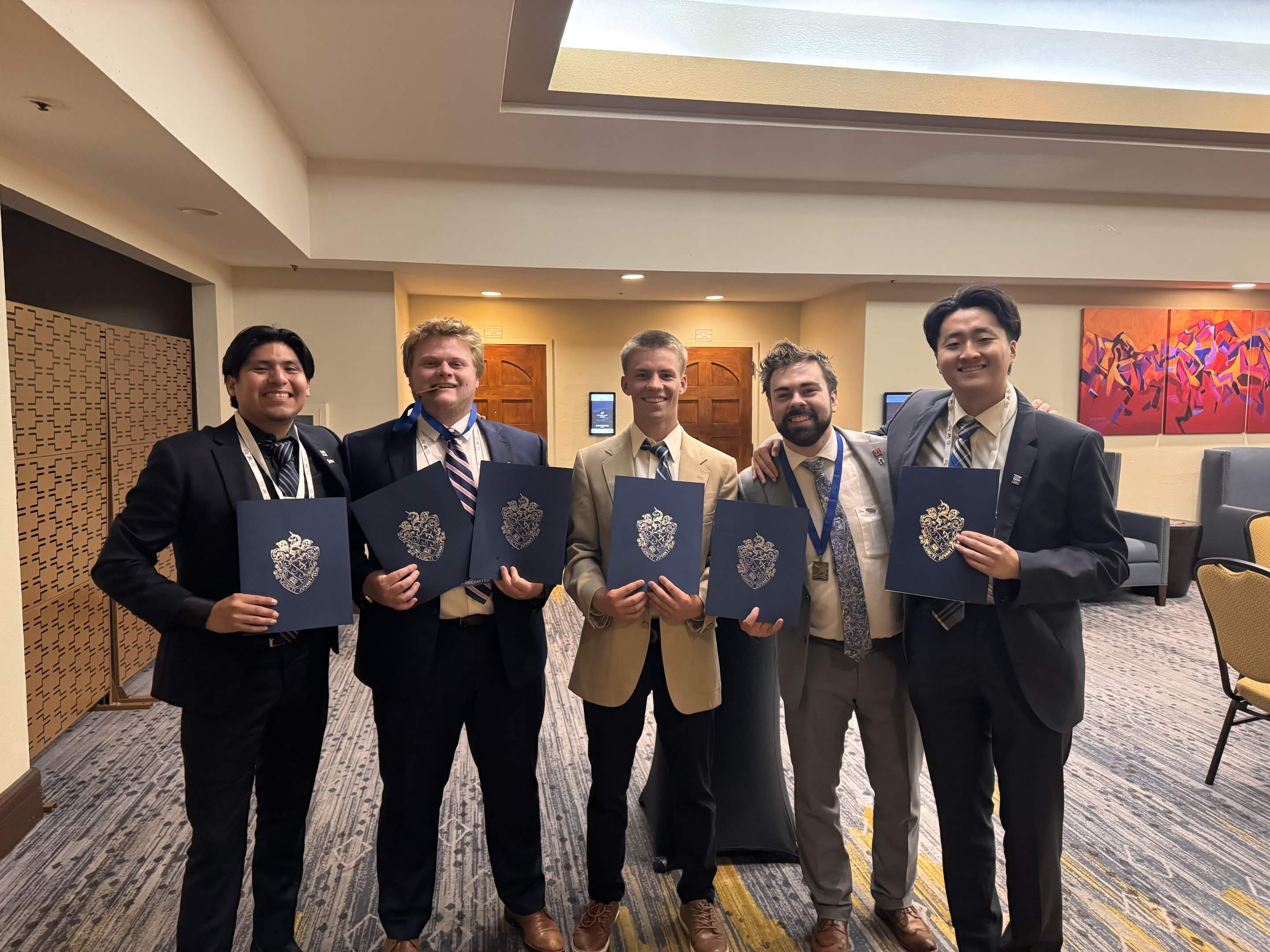 Five Nu Chapter members holding awards