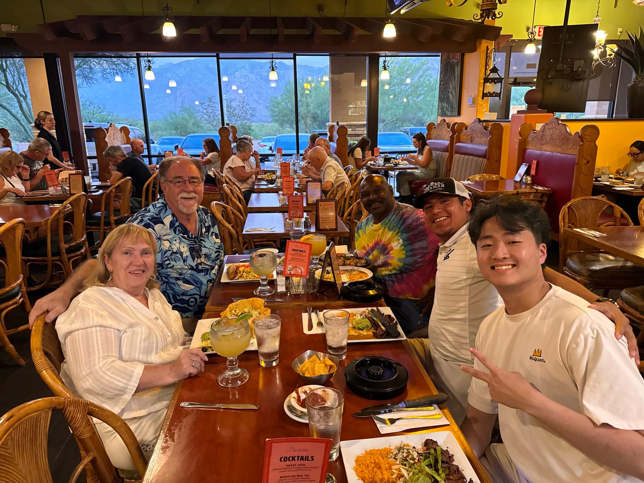 Five people seated together at a restaurant table