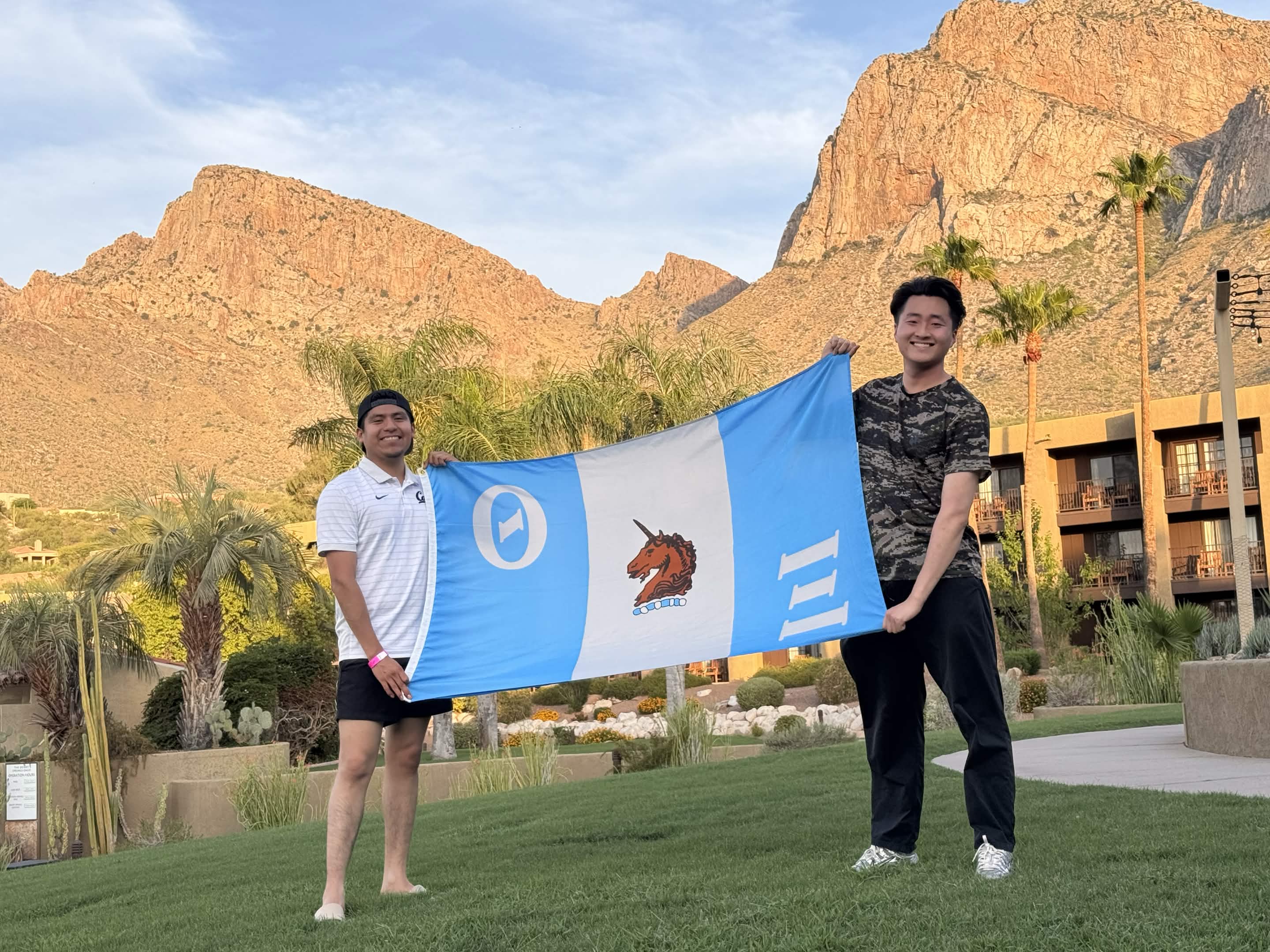 Two Nu Chapter members holding the chapter flag during a trip